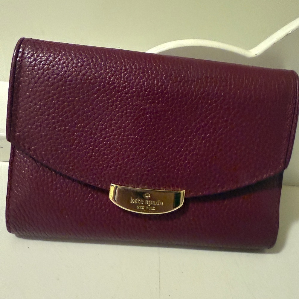 Kate Spade burgundy Leather Clutch with 6 p kets and 7 slots. 5c6 inches